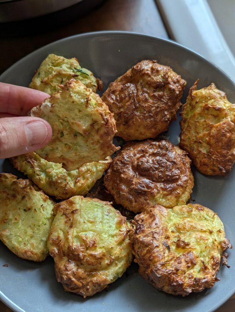 Assiette de beignets de courgettes dorés et croustillants, cuits au Air Fryer, servis chauds