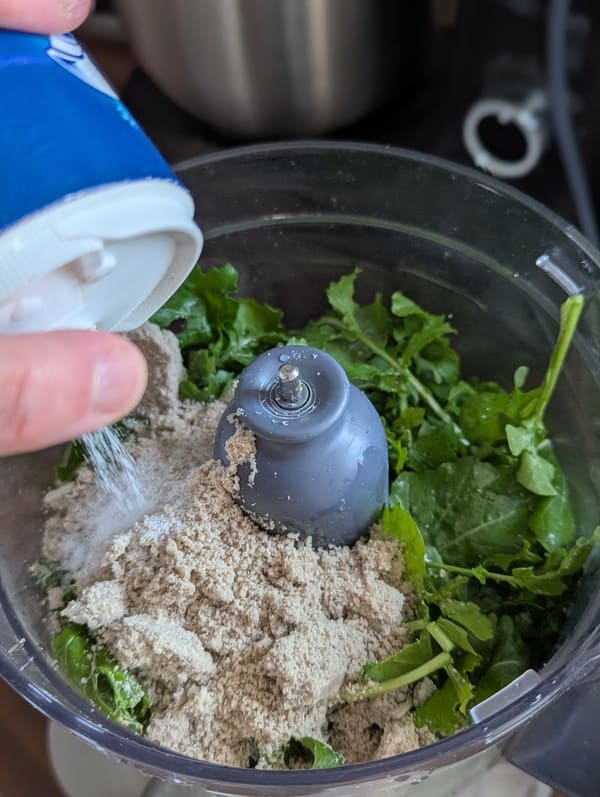 Mélange de la roquette, de l'huile d'olive, de l'huile de colza et de la poudre de tournesol dans le mixeur