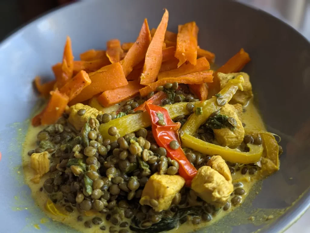 Frites de patate douce au four servies avec du poulet aux lentilles et aux poivrons