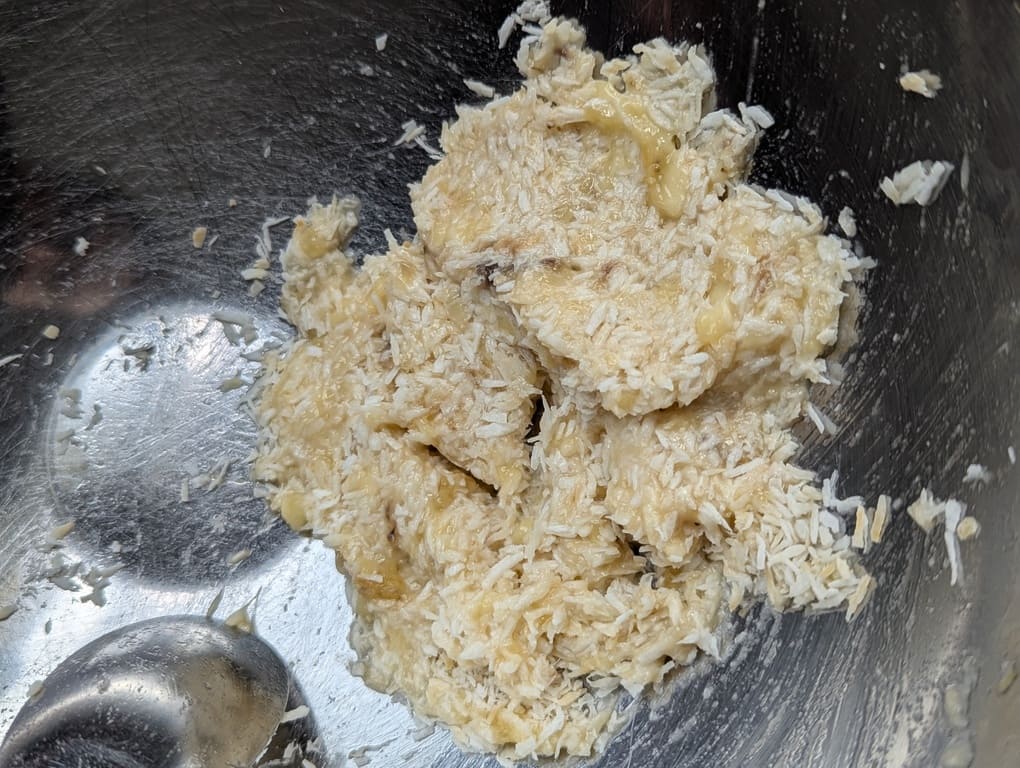 Mélanger la banane écrasée et la noix de coco