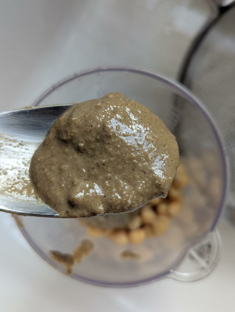 Cuillère de tahin (purée de sésame) au-dessus des pois chiches