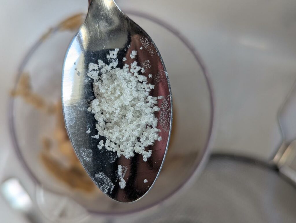 Sel de Guérande dans une cuillère au-dessus du bol du mixeur