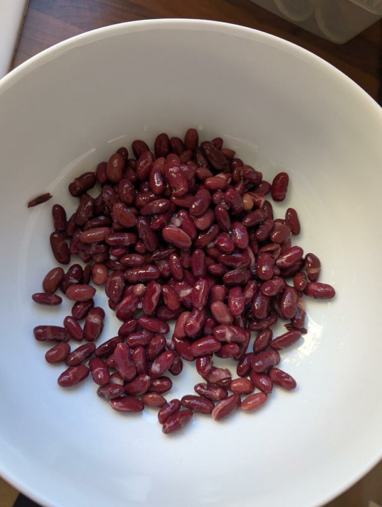 Haricots rouges cuits égouttés et rincés dans un saladier blanc