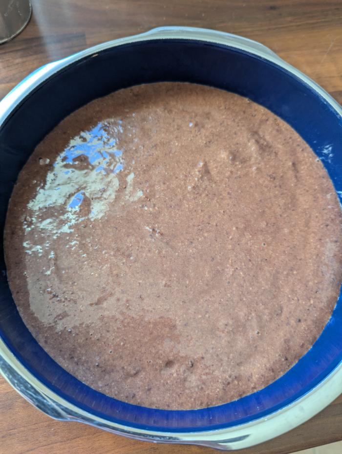 Pâte du gâteau au chocolat aux haricots rouges versée dans un moule rond	