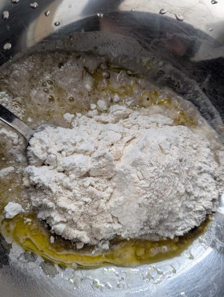 Farines sans gluten ajoutées à la levure dans un saladier en inox
