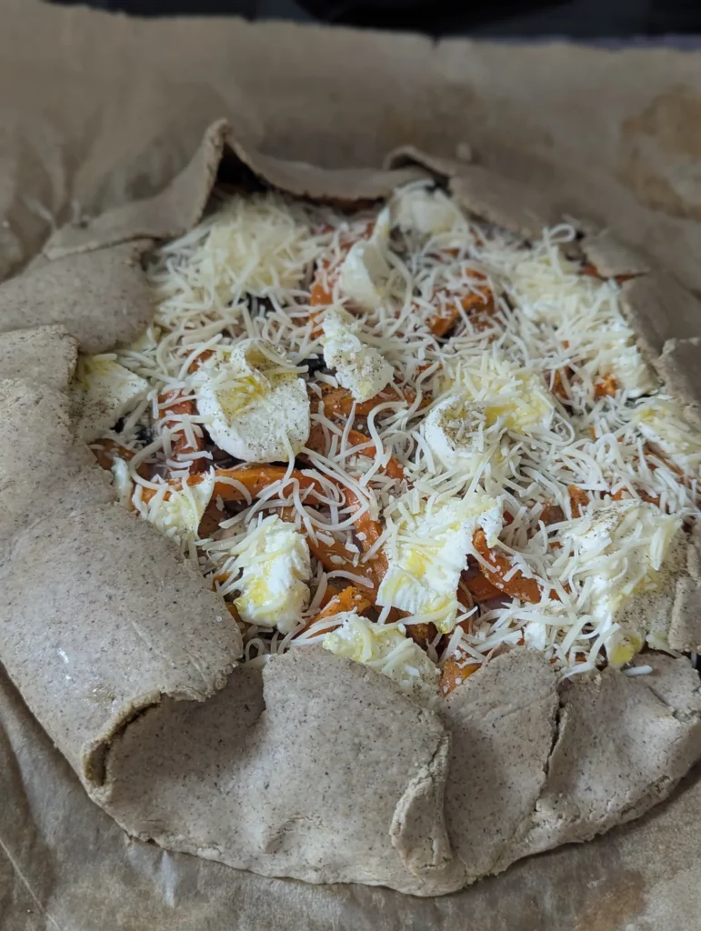 Pizza sans gluten garnie de légumes et fromage avant cuisson bords repliés
