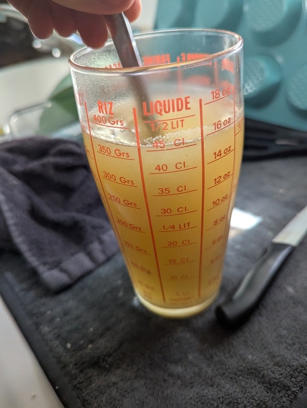 Cube de bouillon dilué dans l’eau chaude, prêt à être ajouté progressivement au riz pour un risotto savoureux.